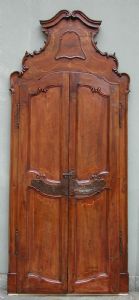 Bella porta in noce massello formellata e di linea mossa con cimasa mossa.Completa di ciambrana  e ferramenteria originale